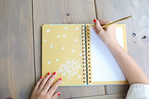 Prayer Journal for Teen Girls – Inspirational Quote & Guided Writing Space Teen girl writing in spiral-bound Prayer Journal for Teen Girls with yellow floral cover and inspirational quote, using gold pen on wooden table