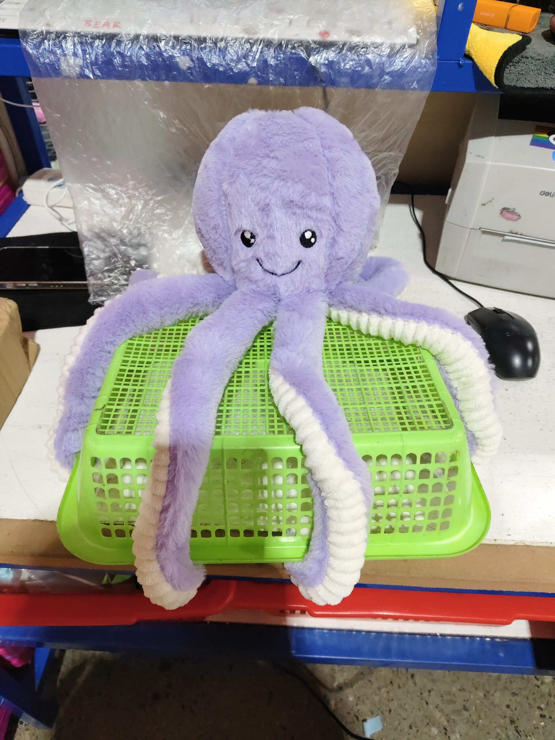 Octopus Stuffed Animal Plushie – Desk Buddy Charm Light purple octopus stuffed animal plushie hanging in front of a computer monitor in a casual workspace.