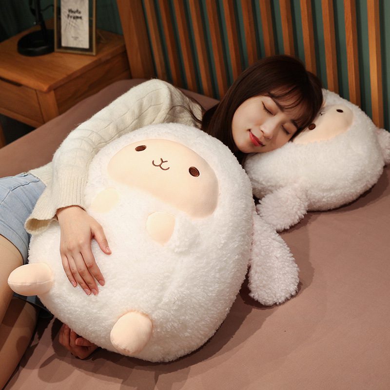 Round Sheep Plushie – Dreamy Duo Person lying on bed cuddling two round sheep plushies, one used as a pillow