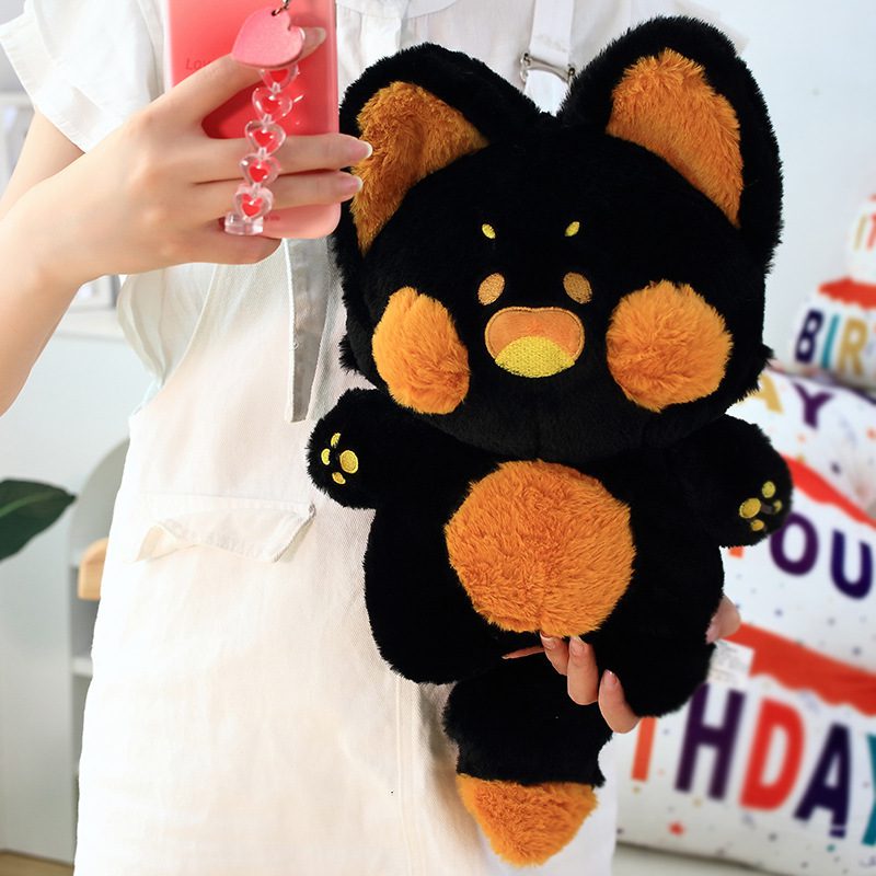 Angel Fox Plushie – Ember Glow Edition Angel Fox Plushie in black with bright orange ears, cheeks, belly, and paws, held by a person.
