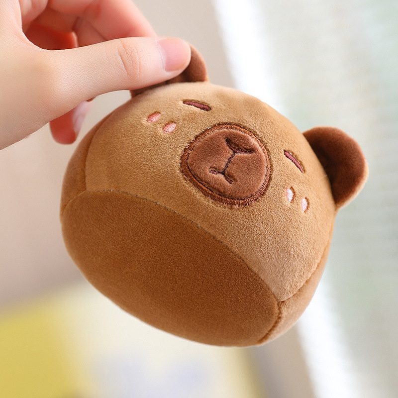 Capybara Plush Toy – Pocket Pal Edition Hand holding a small round plush bear head with embroidered features and blush cheeks.